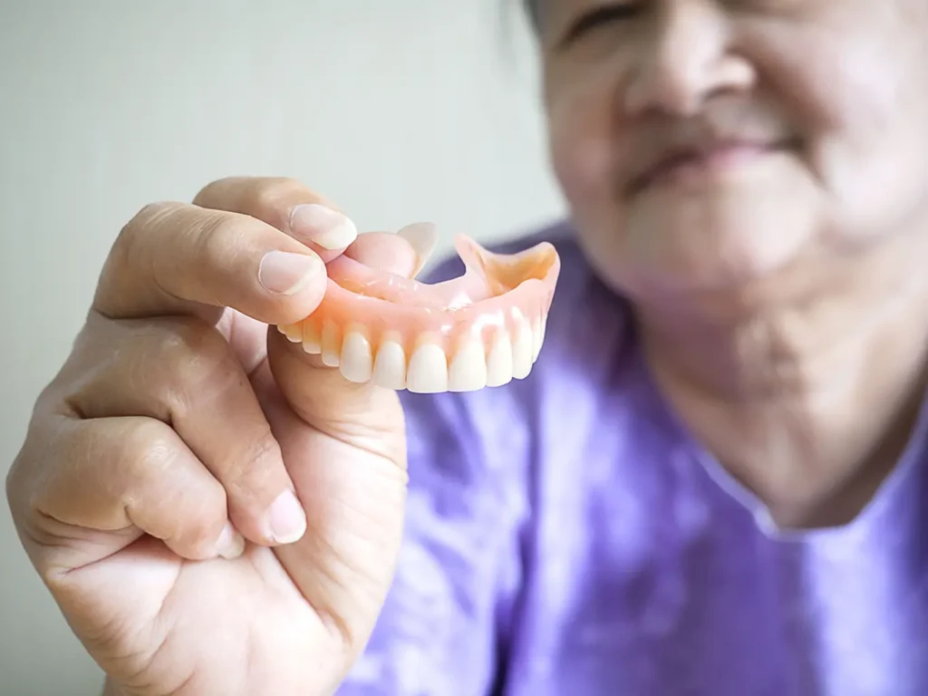 Woman holding out her dentures from Parkway Family Dental