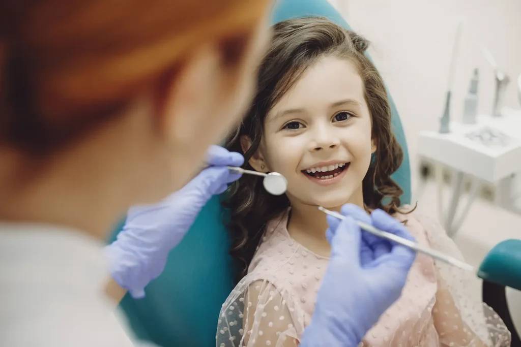 A young girl sitting in dental chair benefiting from Parkway Family Dental's pediatric care